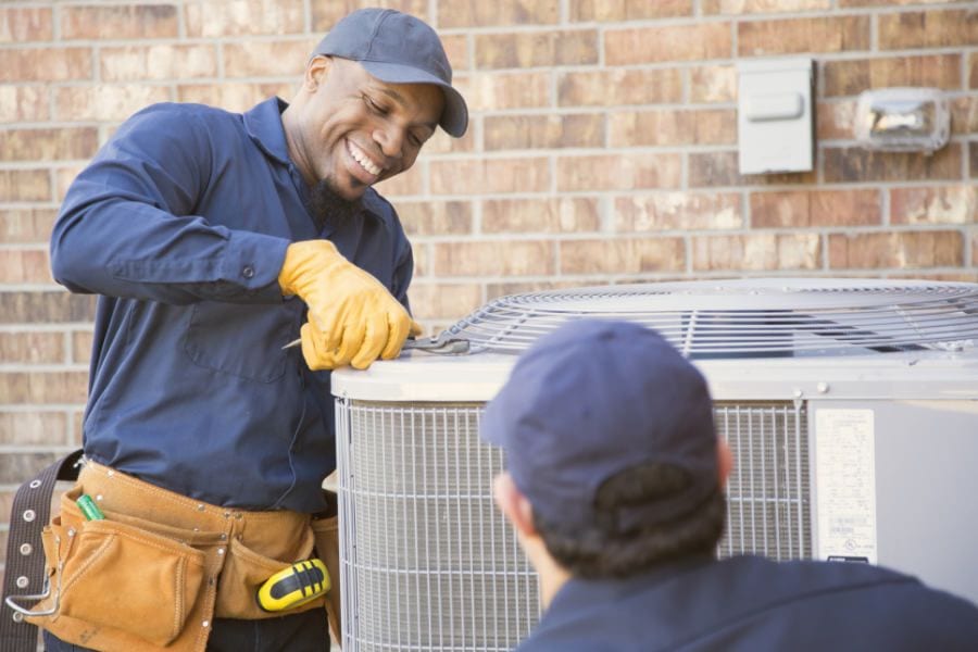 Image of tech. performing ac maintenance. Why Schedule Air Conditioning Maintenance?