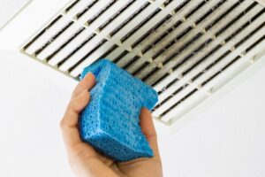 Image of someone cleaning an air duct with a blue sponge. Why Air Duct Cleaning Is Important.