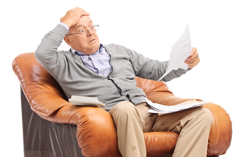 Shocked senior man looking at his bills in disbelief, have your utility bills jumped?