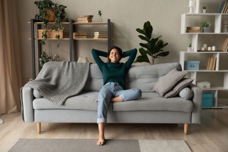 Image of someone sitting on couch. How a Whole-House Humidifier Keeps You Healthy.
